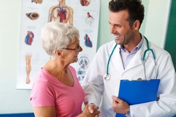 Older lady talking to a smiling doctor